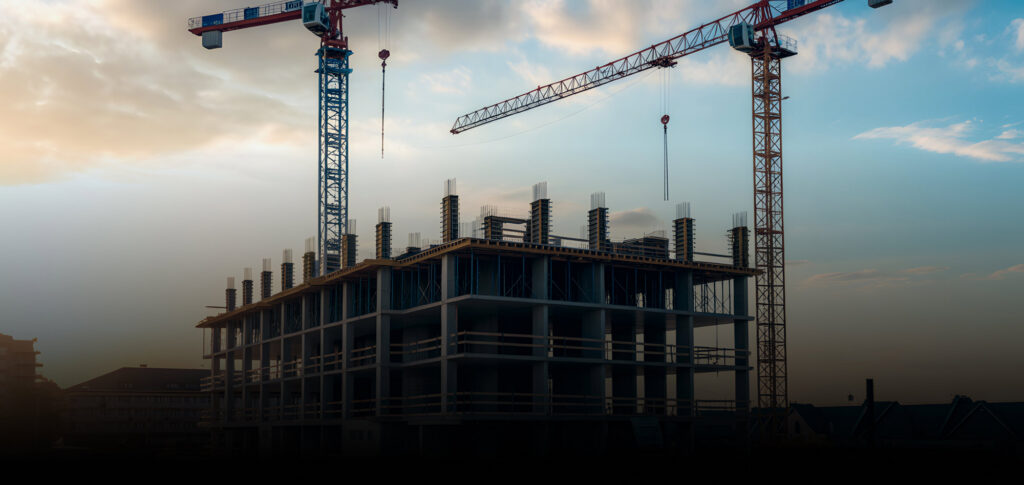 Chantier de construction d'un bâtiment avec des grues protégé par de la télésurveillance