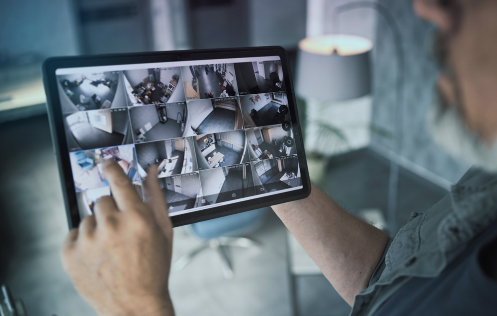 Personne qui regarde des images de vidéosurveillance sur une tablette