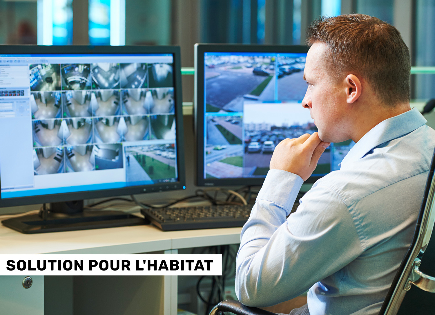 Un homme qui inspecte des images de télésurveillance sur deux écrans